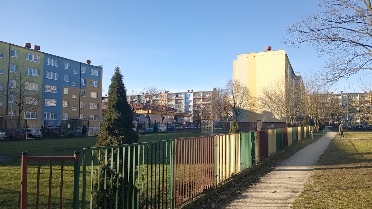 a sidewalk in front of a row of buildings
